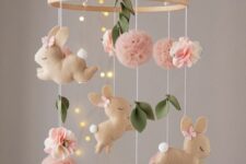 a super cute felt bunny mobile, with pink pompoms, felt leaves and flowers is a lovely solution for a pastel nursery