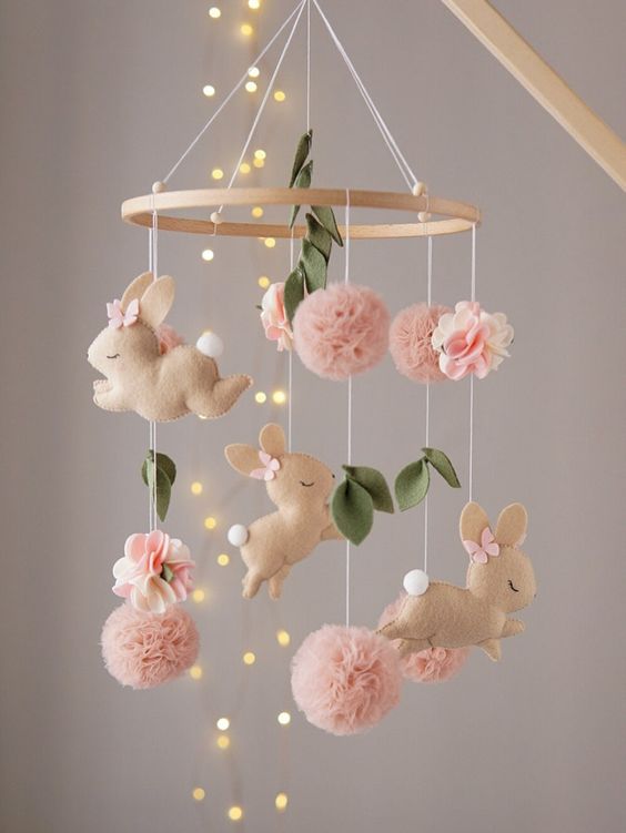 a super cute felt bunny mobile, with pink pompoms, felt leaves and flowers is a lovely solution for a pastel nursery