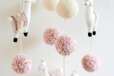 a super fun boho mobile with white and pink pompos and llamas will be a nice fit for a boho chic nursery