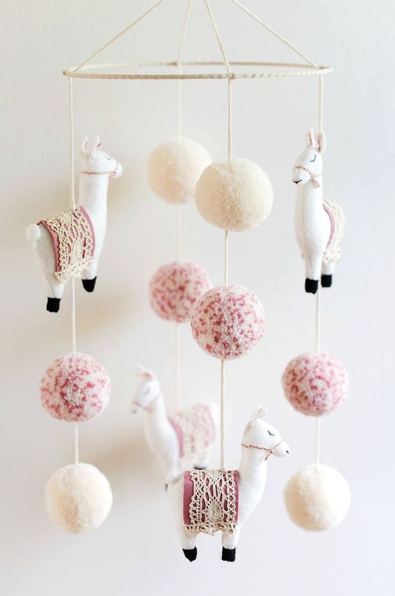 a super fun boho mobile with white and pink pompos and llamas will be a nice fit for a boho chic nursery