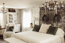 a white shabby chic bedroom with shabby shutters over the bed, refined white furniture, crystal chandeliers and printed textiles