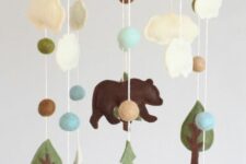 a woodland mobile with mountains, pompoms, clouds, trees and a bear is a cool and stylish solution made of felt