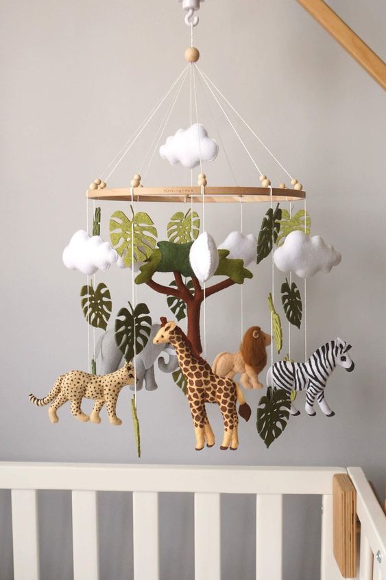 an African themed nursery with savanna naimals, monstera leaves and clouds is a super cool and bold idea for the space