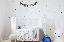 an airy Scandinavian kid’s room with a polka dot wall, a white bed, some printed textiles and cool and simple toys