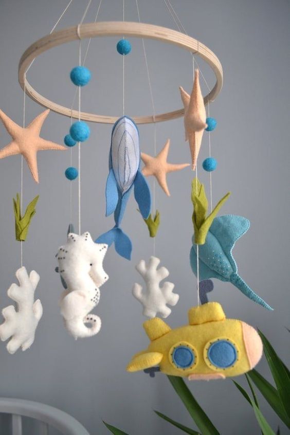 an under the sea mobile with corals, starfish, whales, fish and a submarine is a fun idea for an ocean space