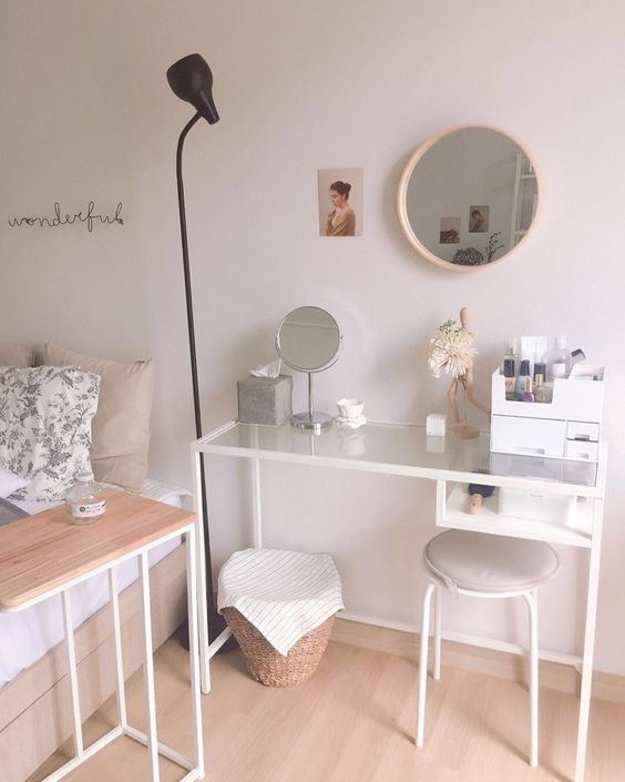 a Vittsjo table turned into a comfortable vanity, with makeup storage, a mirror and a round mirror on the wall, a basket for storage