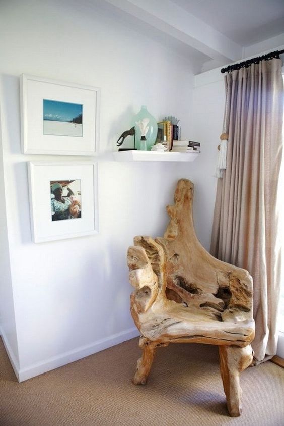 a beautiful driftwood chair, some ocean inspired artworks and a shelf with corals create a sea inspired nook here