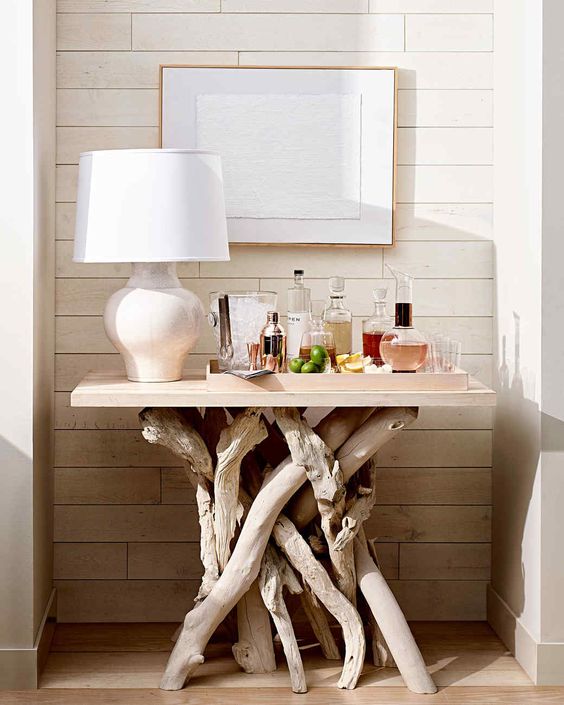 a beautiful table used as a home bar and made of whitewashed driftwood and a white tabletop is a very creative and cool solution for a modern space