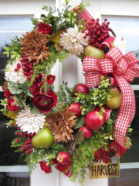 a bold fall wreath of greenery, natural and dried blooms, faux fruit and berries and a bold plaid bow