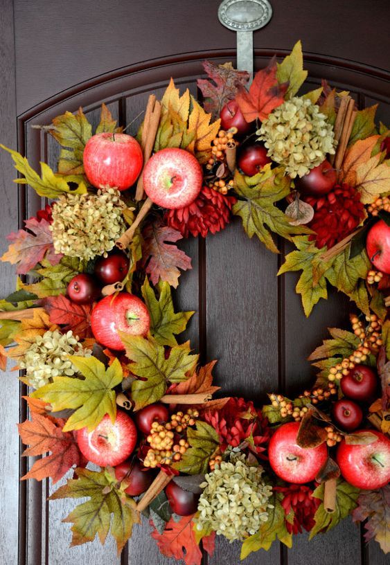 a bright and chic fall wreath of faux foliage, apples, berries, dried hydrangeas, cinnamon sticks will have a fall aroma