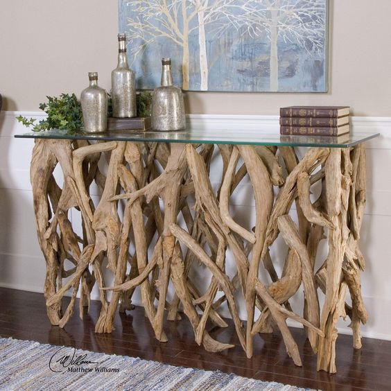 a chic console table of lots of driftwood and a glass tabletop is a refined and cool idea for a beachy or eco friendly interior