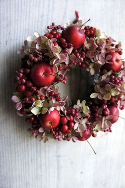 a chic fall wreath of dried blooms, berries and red apples is a small and cute decoration for your porch