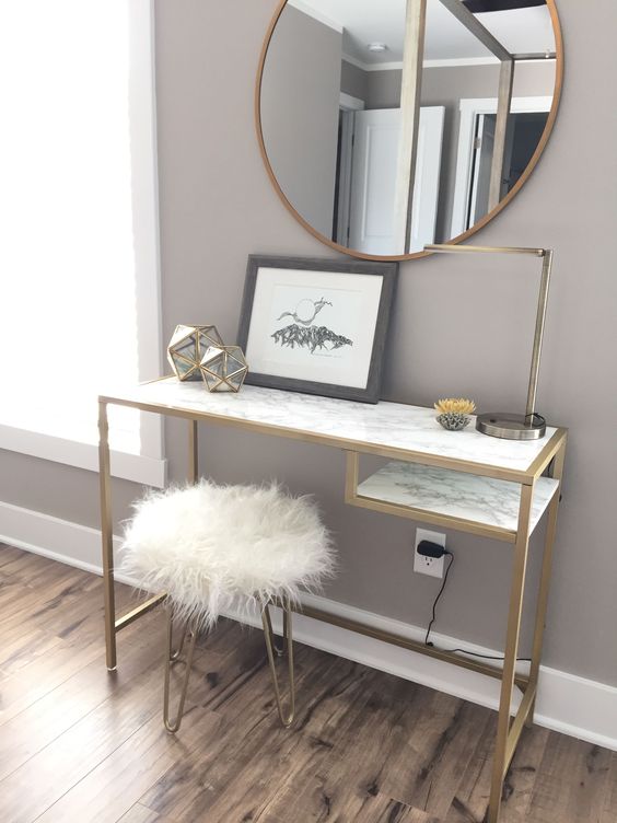 a chic working space with a Vittsjo desk hacked with marble adhesives and gold paint, chic faceted candleholders and a brass table lamp