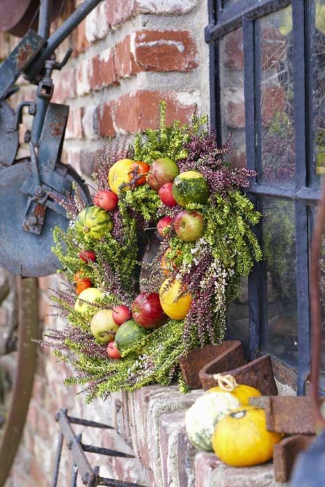 a classy fall wreath of greenery, fresh blooms, apples and gourds is very farm-like and very natural
