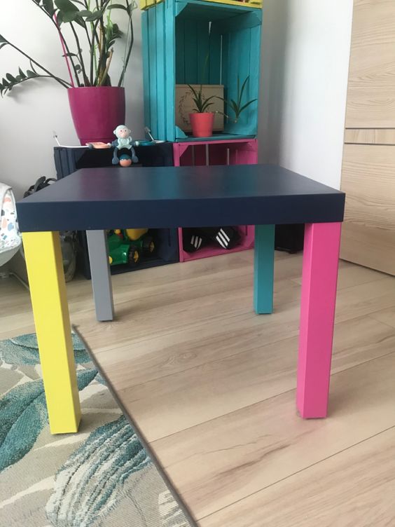 a colorful IKEA Lack table hack with a black tabletop and mismatching colorful legs is a great idea for a bold room