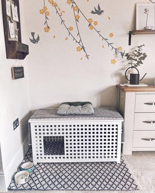 a cozy pet retreat made of an IKEA Hol table with an additional bed on top and food bowls by the side