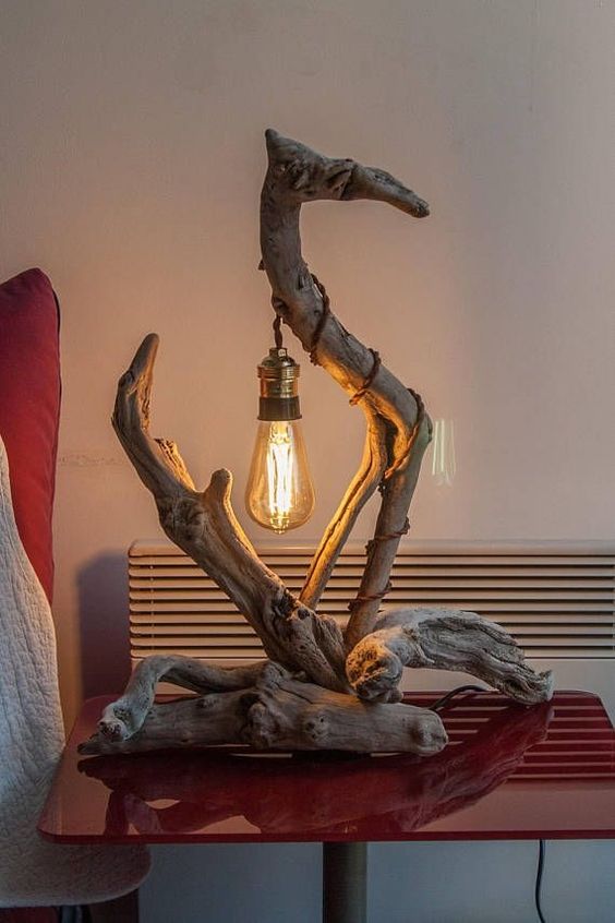 a creatively looking table lamp of driftwood and a hanging bulb is a cool piece that you can DIY easily