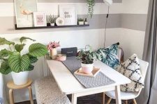 a cute and cozy dining nook with a table, chairs and a bench, open shelves, some artworks, potted greenery is lovely