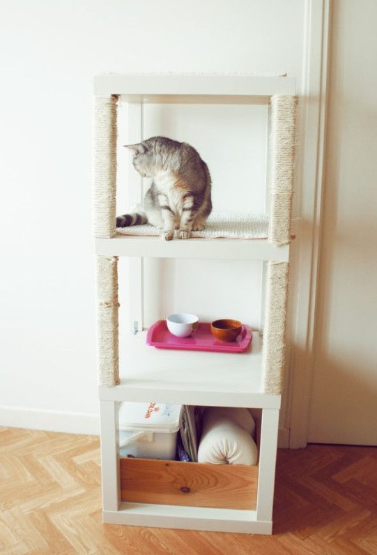 a cute and welcoming cat tower built of several Lack tables includes sleeping, feeding and storage zones