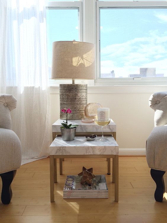 a duo of IKEA Lack tables renovated with marble contact paper and gold spray paint