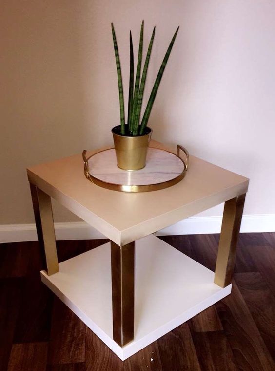 a glam nightstand or plant stand of two IKEA Lack coffee tables with white tabletops and gold legs is shiny and chic