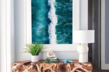 a gorgeous driftwood console table and an ocean print turn the entryway into a fantastic seaside space and they look wow