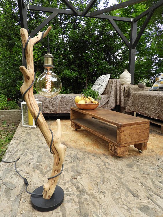a gorgeous outdoor driftwood floor lamp with an oversized bulb is a beautiful idea for an oitdoor space and it's easy to craft