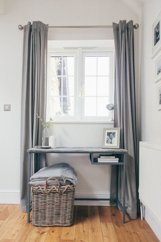 a lovely window nook with a grey Vittsjo table with a wooden tabletop, a basket with pillows and a blanket and grey curtains is amazing