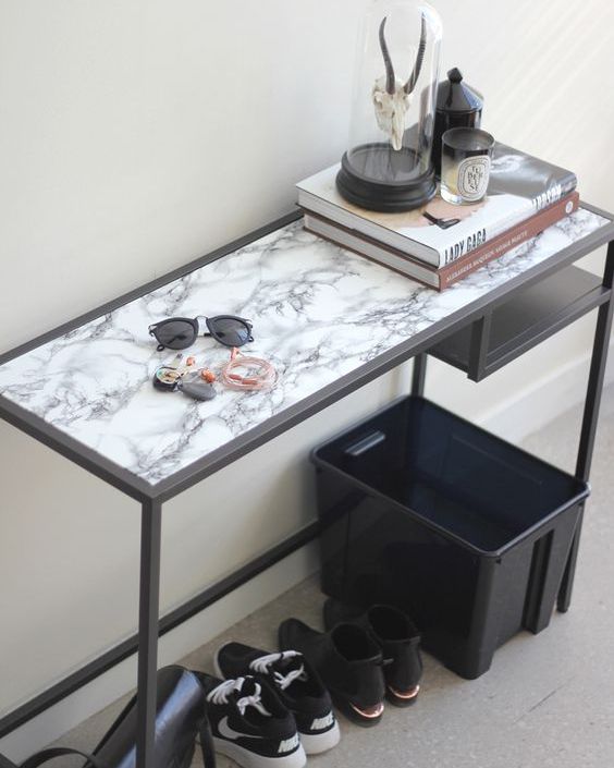 a modern entryway console table of an IKEA Vittsjo desk with a marble adhesive paper top is a stylish idea for a Scandi space