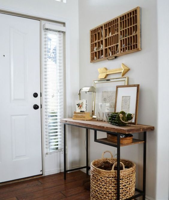 a rustic console table of a Vittsjo desk plus a rough wooden tabletop, a basket for storage, cool art and a table lamp and a board for storing keys