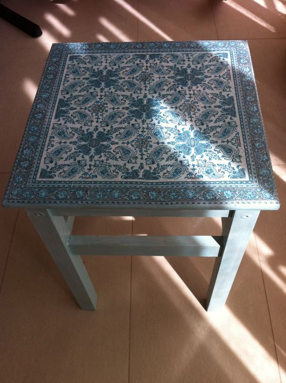 a slate blue IKEA Oddvar stool with a beautiful decoupage seat can be used as a side table or a chair