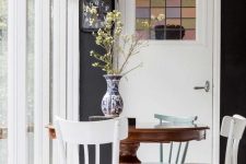 a small and colorful dining space with a vintage dark stained round table, chairs with colorful legs, pendant lamps on colorful cords