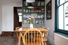 a vintage dining space with a wooden dining set, a blue storage unit and black pendant IKEA Ranarp lamps