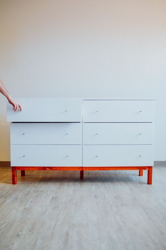 a white Tarva dresser hack with tiny knobs and a red frame and legs for a contemporary space