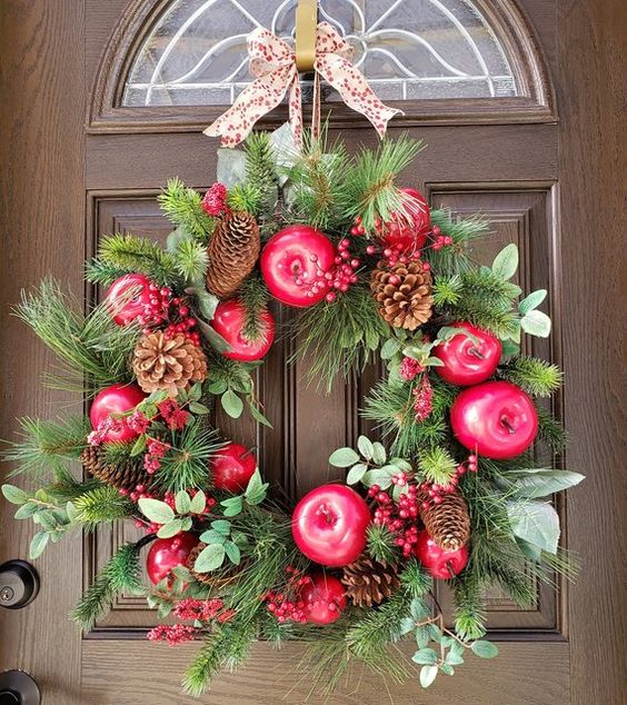 a wild fall wreath of evergreens, faux apples, pinecones, berries and eucalyptus plus a polka dot ribbon bow on top