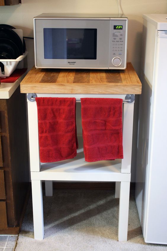 add counter space to your kitchen using a couple of IKEA Lack tables like here, with a butcherblock countertop and red towels