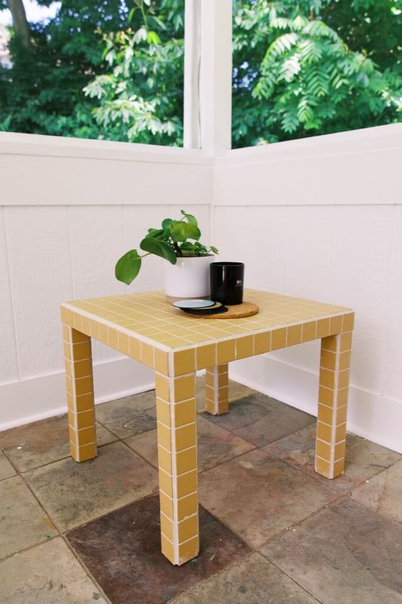an IKEA Lack table covered with yellow tiles all over is a stylish and bold accent in the interior that can withstand any conditions