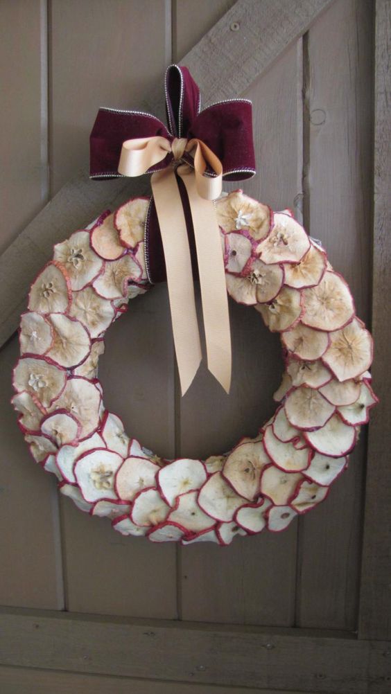 an elegant apple slice fall wreath with a chic purple velvet bow on top is a cool fall decoration