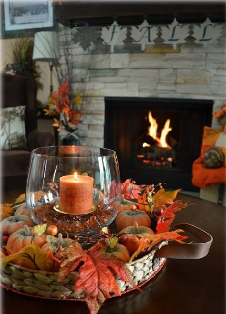 a basket tray with faux pumpkins, berries, leaves and a rust-colored candle in a candle holder with rust rhinestones is very rustic and cool