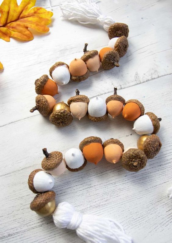 a beautiful and cozy fall and Thanksgiving garland composed of faux acorns and tassels is a lovely idea to make yourself