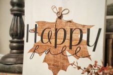 a beautiful fall sign in white and with a stained fall leaf and a button is super cute and fun