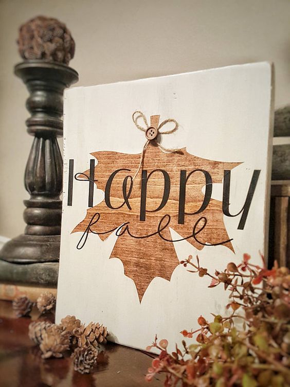 a beautiful fall sign in white and with a stained fall leaf and a button is super cute and fun