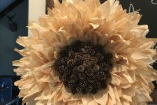 a bold and catchy corn husk and pinecone wreath that imitates a sunflower is a fantastic rustic decoration to make