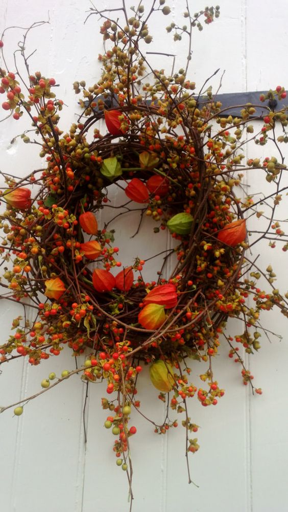 a branch and twig fal wreath with dried blooms, blooming branches and berries is a colorful fall piece