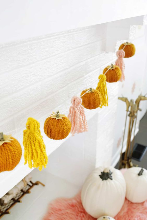 a bright and fun fall garland of yarn pumpkins and tassels is a lovely idea for fall and Thanksgiving