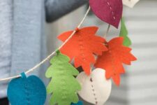a bright fall banner of bold fall leaves cut out of felt is a fun and cool idea that can be easly made by you yourself