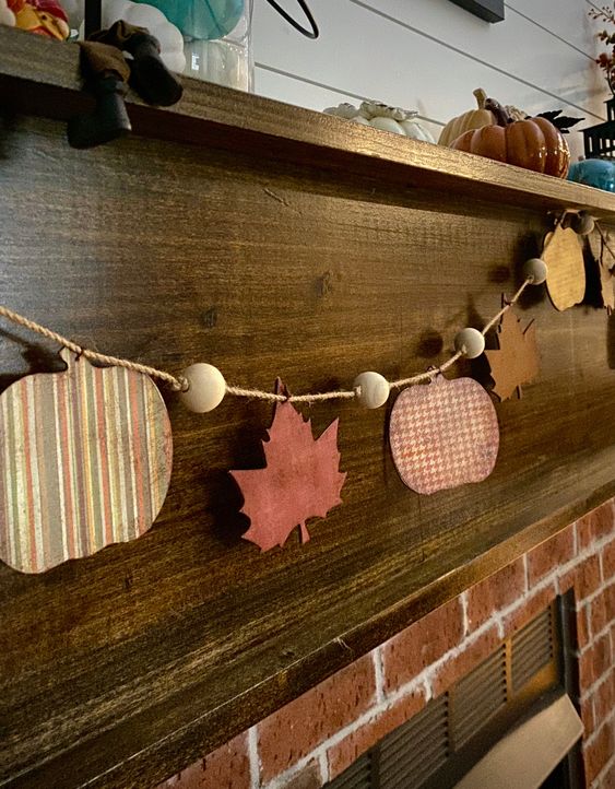 a bright rustic fall garland with wooden beams and wooden plaques styled as pumpkins and leaves is a lovely solution