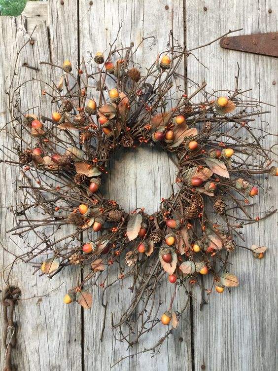 a brigth natural fall wreath with twigs, acorns, berries, pinecones is lovely way to add a woodland feel to the space
