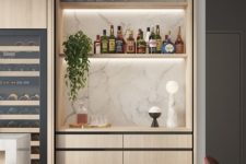 a built-in minimalist mini bar in the kitchen, with a marble backsplash, built-in shelves with lights and sleek drawers