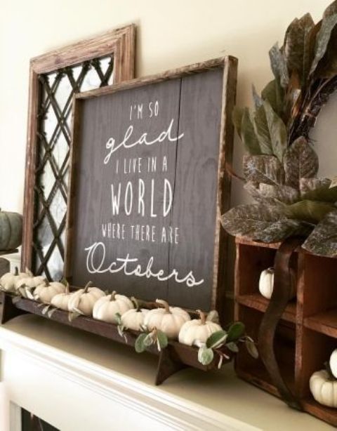 a chic chalkboard sign with white letters, a tray with white pumpkins and leaves for a fall mantel